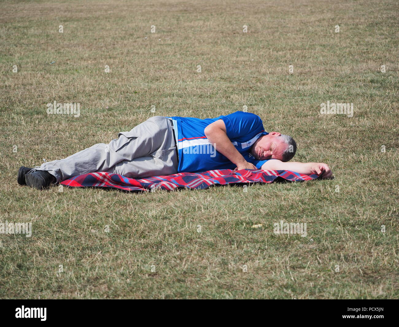 Minster sur mer, Kent, UK. 4 Août, 2018. Météo France : une journée ensoleillée et chaude à Minster sur mer, Kent en tant que spectateurs au Festival de pas Pirates Sheppey s'asseoir sur l'herbe de Sheppey Rugby Club à l'heure du déjeuner. Credit : James Bell/Alamy Live News Banque D'Images