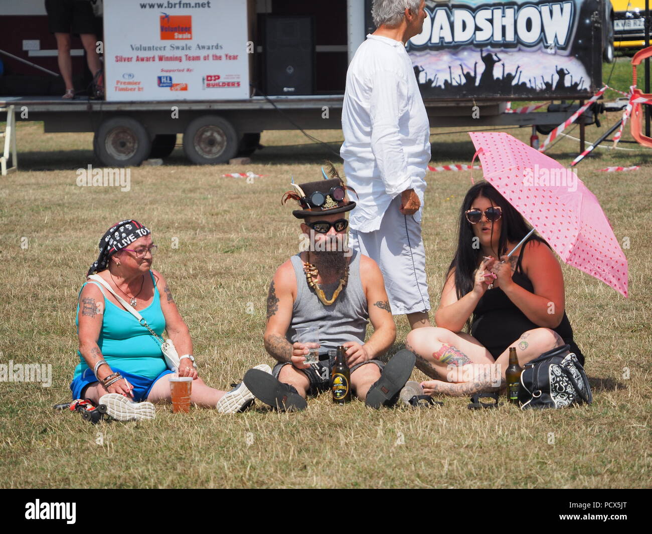 Minster sur mer, Kent, UK. 4 Août, 2018. Météo France : une journée ensoleillée et chaude à Minster sur mer, Kent en tant que spectateurs au Festival de pas Pirates Sheppey s'asseoir sur l'herbe de Sheppey Rugby Club à l'heure du déjeuner. Credit : James Bell/Alamy Live News Banque D'Images