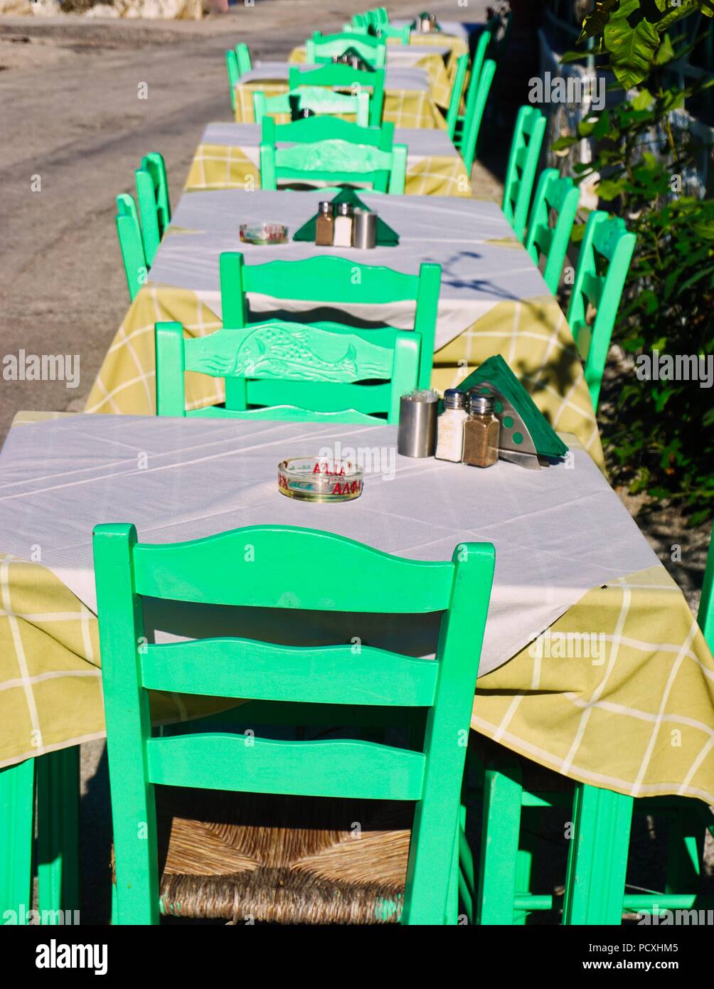 Peints de couleurs vives, éclatantes de chaises à l'extérieur restaurant grec, Paxos Banque D'Images