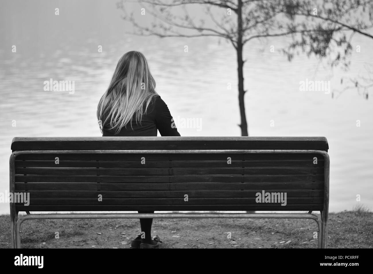 La femme assise sur le banc Banque D'Images