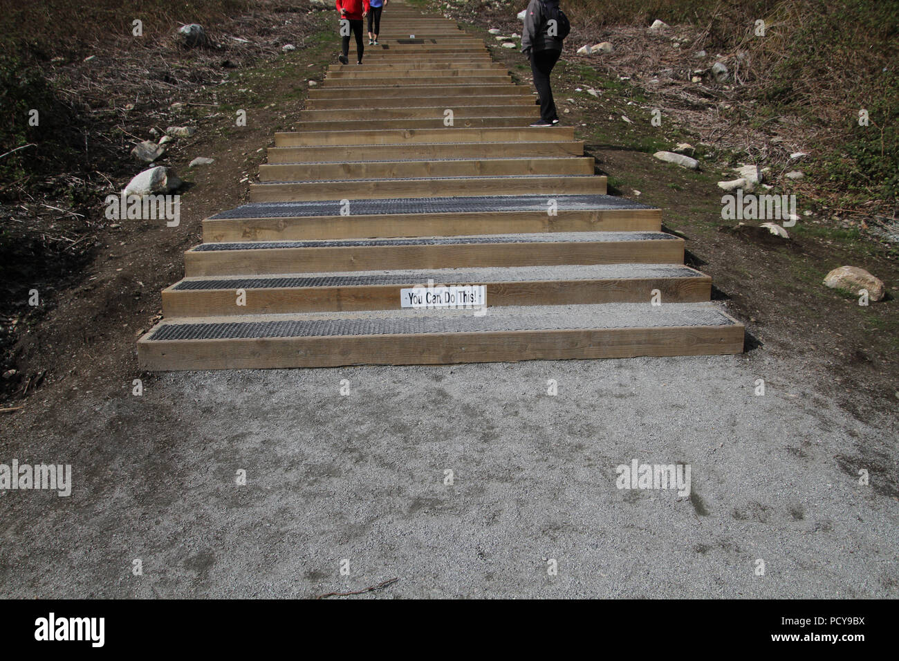 Un vous pouvez le faire en bas de l'escalier en bois avec marches métalliques menant à un sommet d'une colline avec des personnes marchant sur eux Banque D'Images