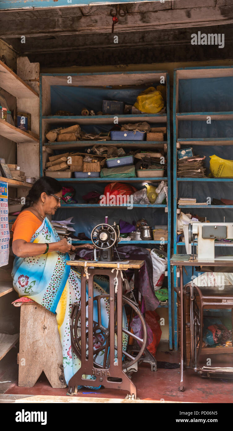 Shravanabelagola, Karnataka, Inde - 1 novembre, 2013 : Sara habillé sur mesure féminin sur ses pieds-powered machine à coudre dans son atelier. Contexte de la charge Banque D'Images