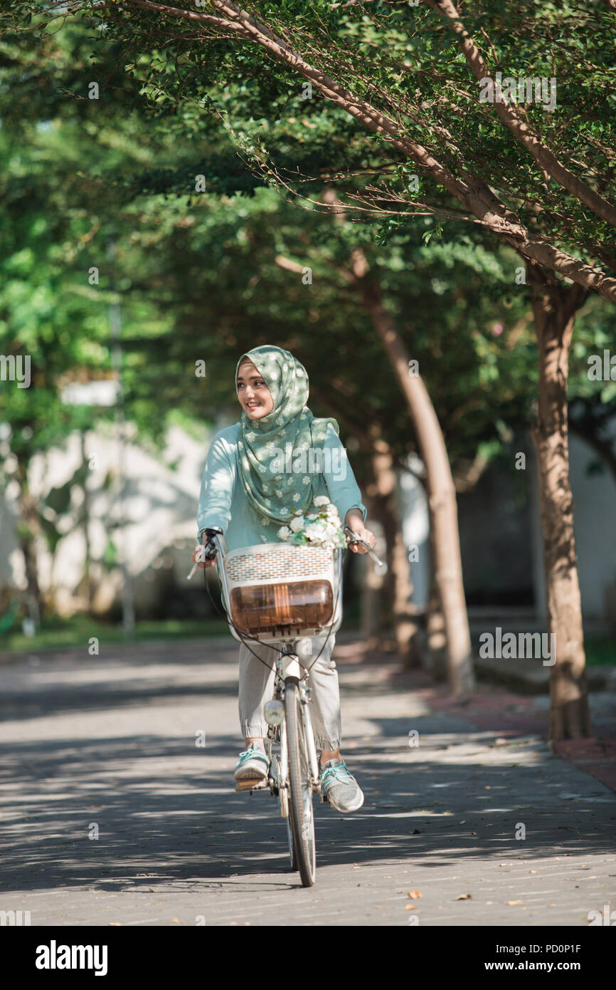 Femme portant le hijab riding a bike Photo Stock - Alamy