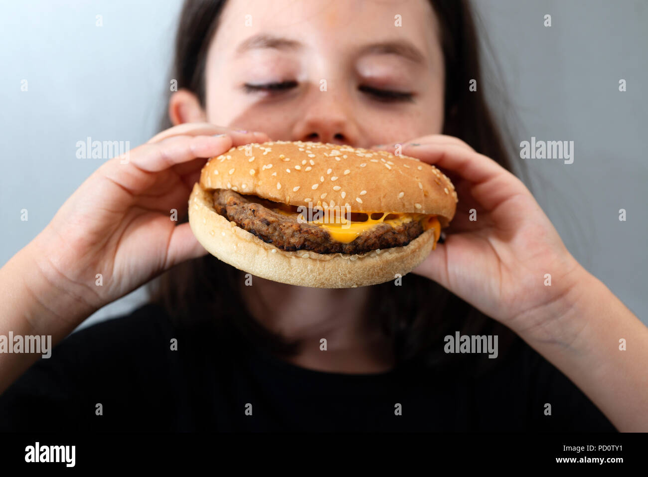 Girl eating a hamburger au fromage Banque D'Images