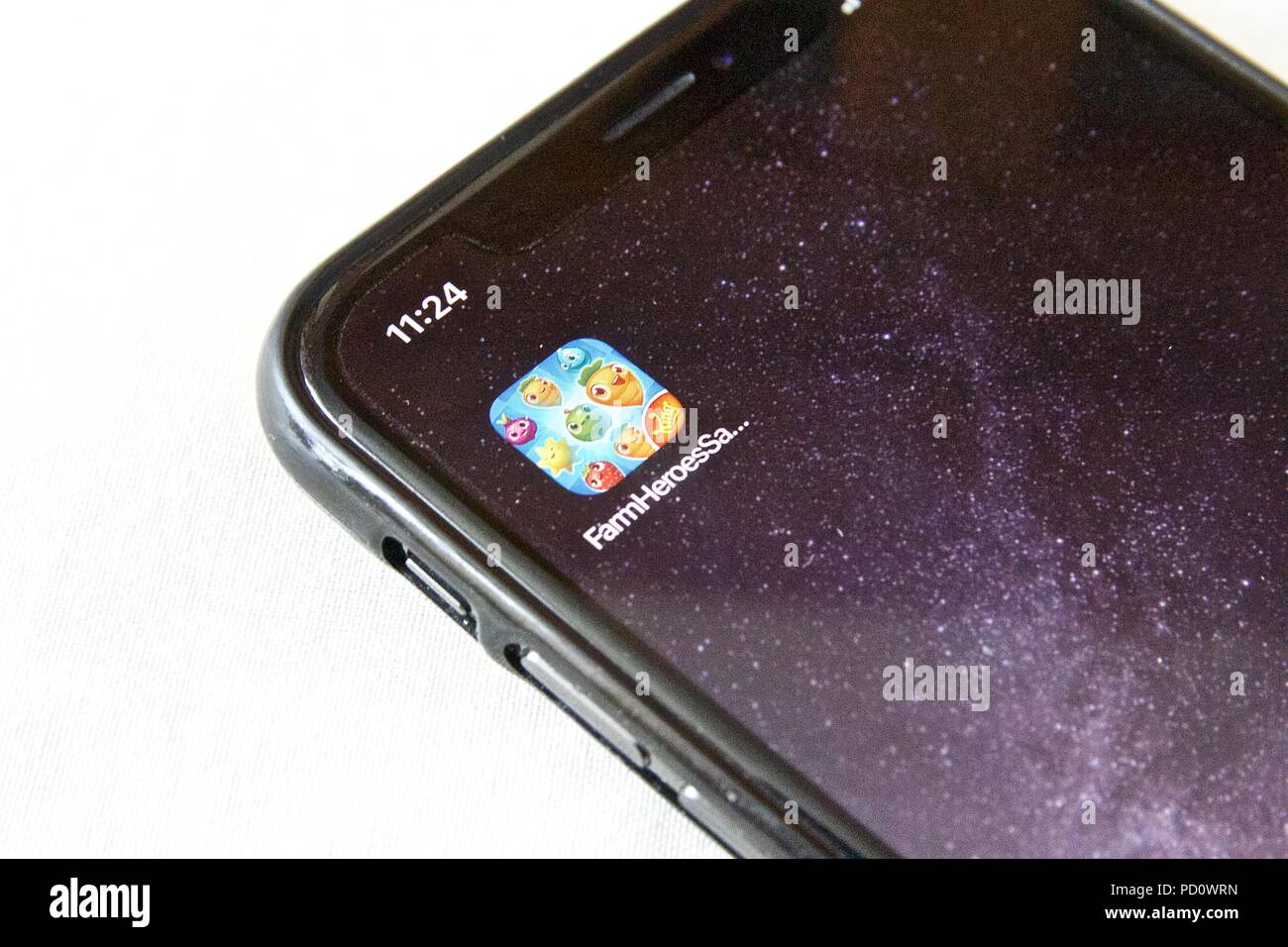 L'icône de l'application pour les héros de la ferme, une ferme Saga puzzle match 3 jeu à thème fait par le Roi, sur un iPhone X sur un fond blanc. Banque D'Images