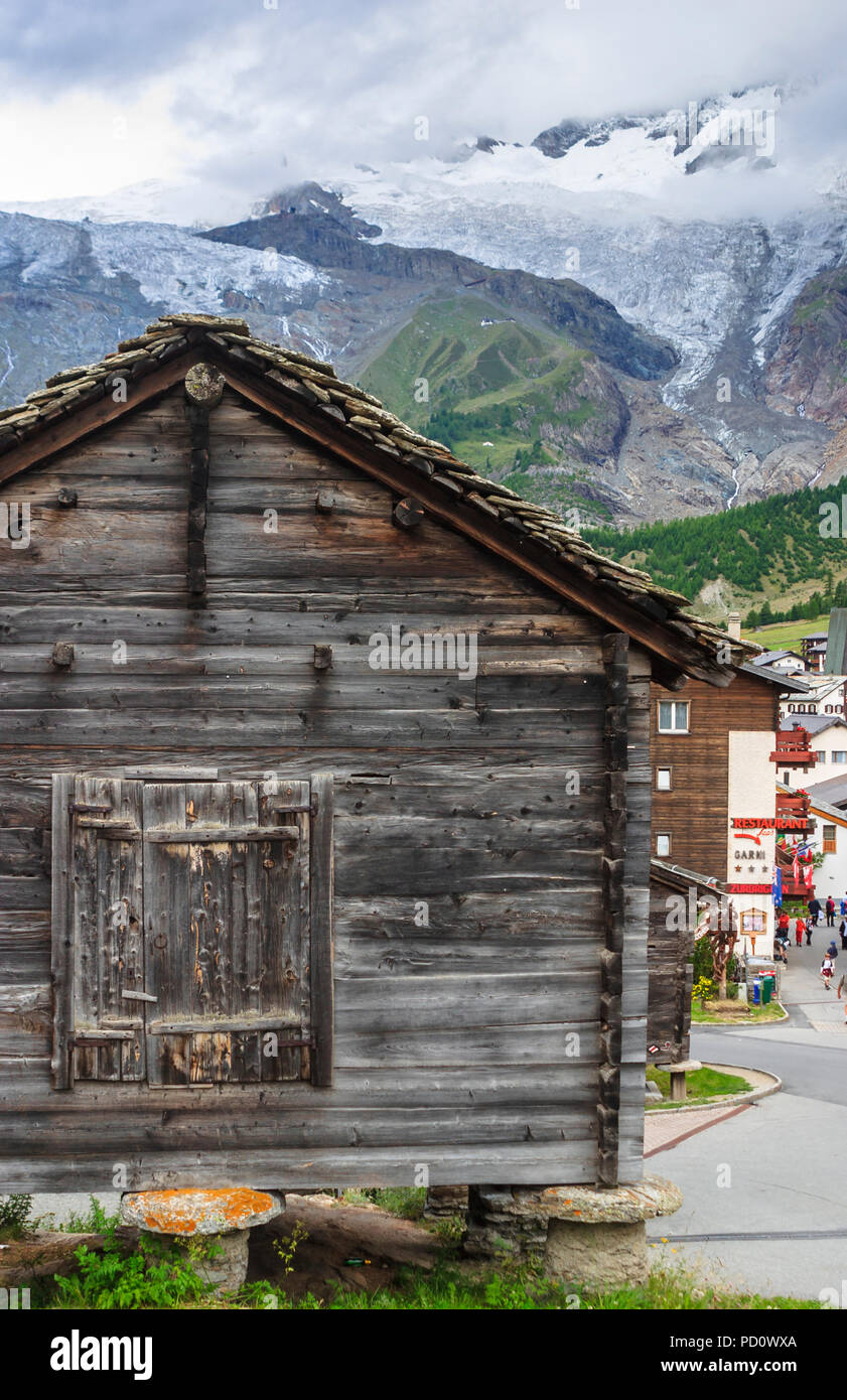 Cabane en bois traditionnel sur staddle pierres à l'entrée dans le village de Saas Fee Saastal (Vallée de Saas) dans le canton du Valais, Suisse Banque D'Images