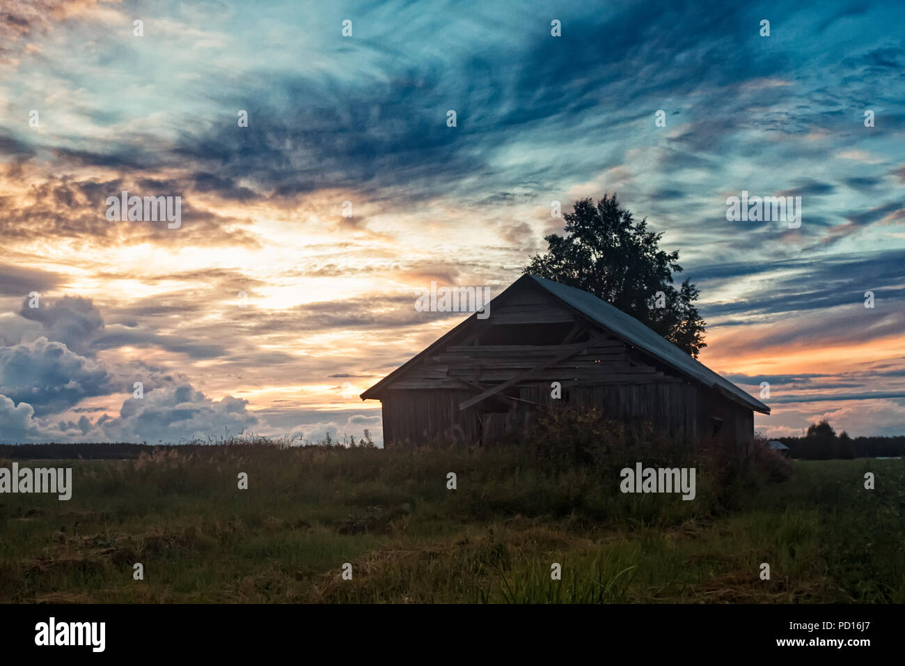 Une ancienne grange se trouve sur le champs d'été dans une soirée à la fin de l'été du nord de la Finlande. Les nuits sont de plus en plus sombre que l'automne est presque Banque D'Images