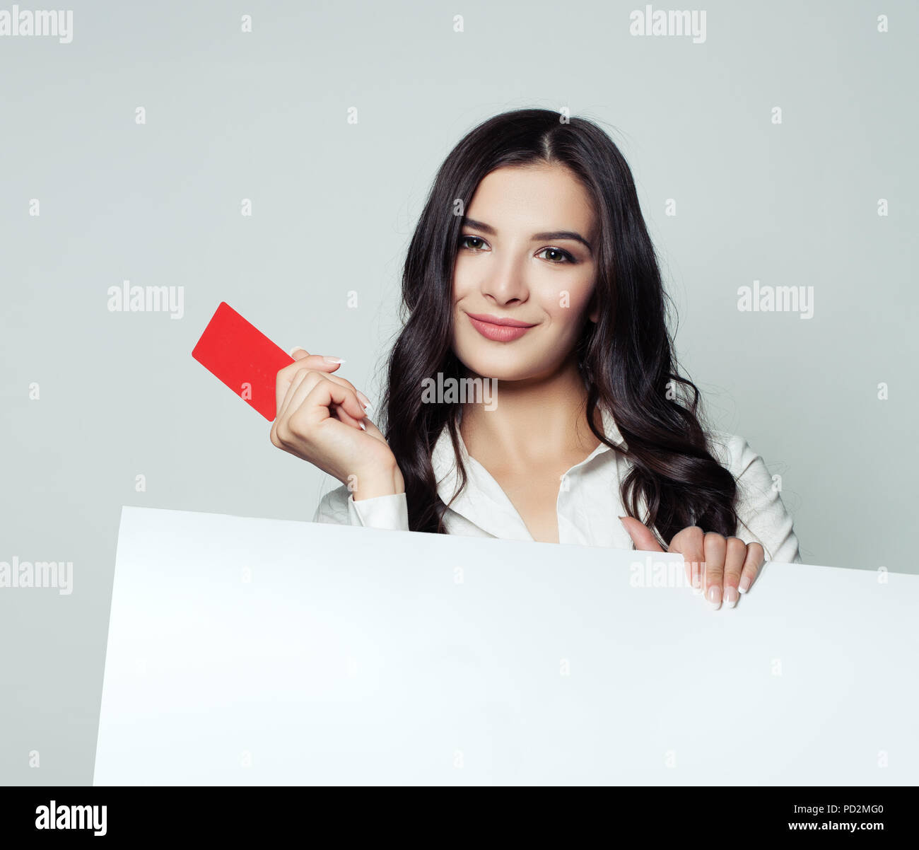 Young happy business woman showing red carte vide et holding white blank banner backround. Des affaires, de la publicité et du placement de produit marketing conc Banque D'Images
