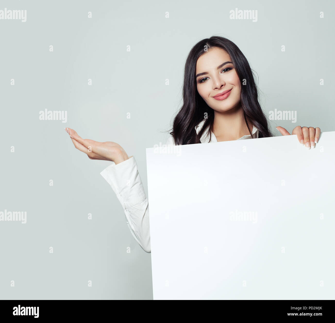 Happy business woman showing empty main ouverte et holding white papier blanc arrière-plan. Young woman smiling, concept d'affaires et d'éducation Banque D'Images