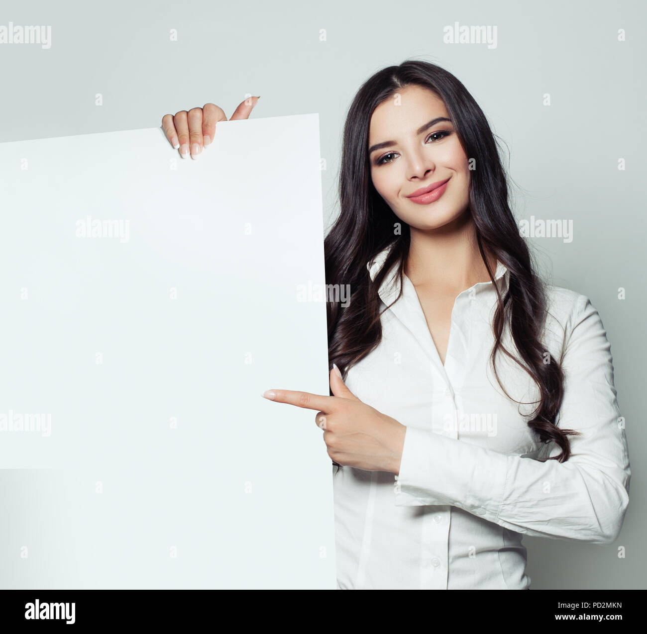 Smiling business woman holding white papier blanc arrière-plan et de pointage. Femme étudiant confiant, l'entreprise et de l'éducation concept Banque D'Images