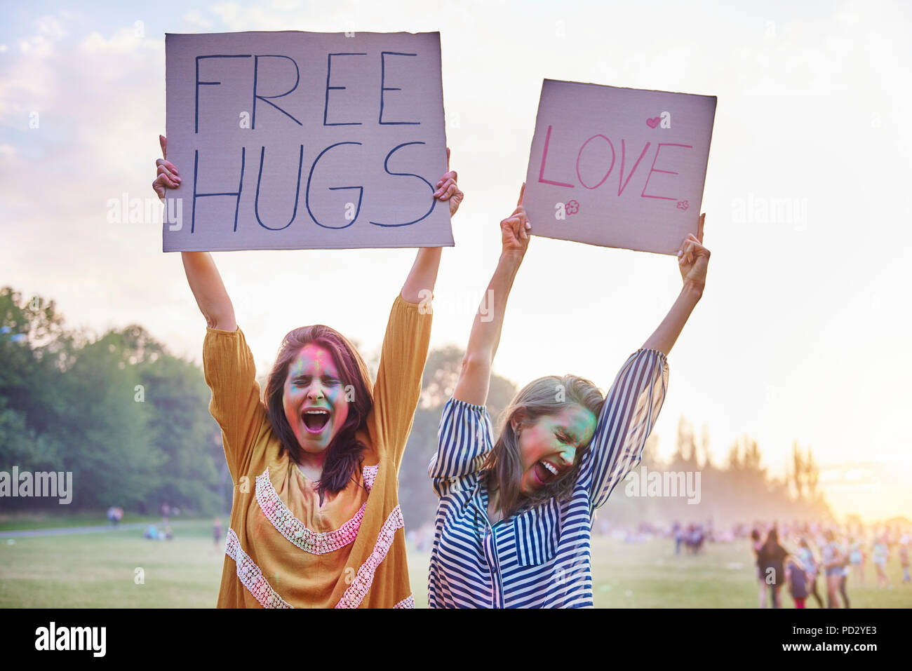 Les jeunes femmes danser holding up amour et gratuitement des affiches aux hug Festival Holi Banque D'Images