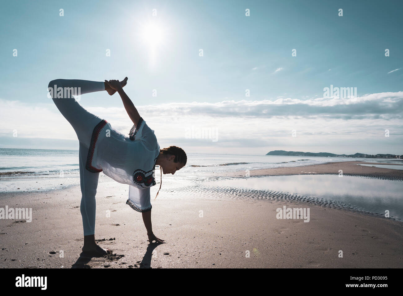 Woman practicing yoga on beach Banque D'Images
