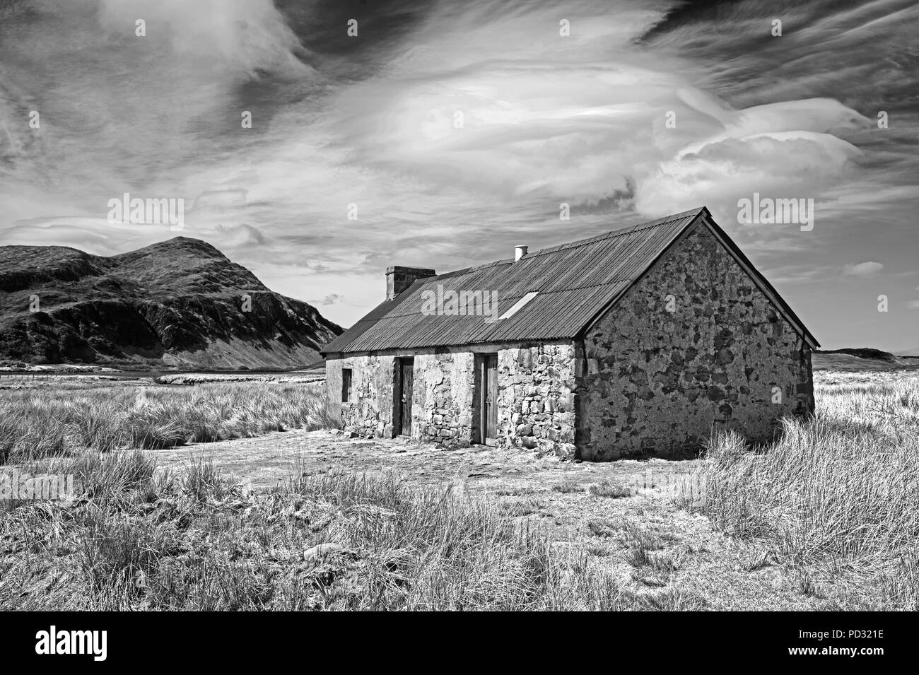 Vieille cabane traditionnelle dans les landes, Sutherland, les Highlands écossais, la montagne Ben pile dans l'arrière-plan, en Écosse au Royaume-Uni. Banque D'Images