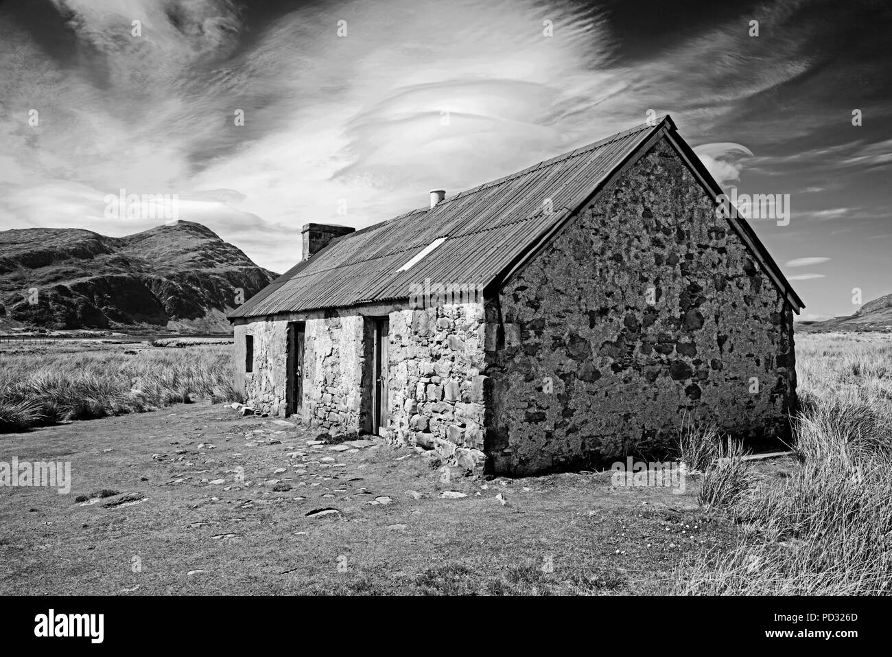 Vieille cabane traditionnelle dans les landes, Sutherland, les Highlands écossais, la montagne Ben pile dans l'arrière-plan, en Écosse au Royaume-Uni. Banque D'Images