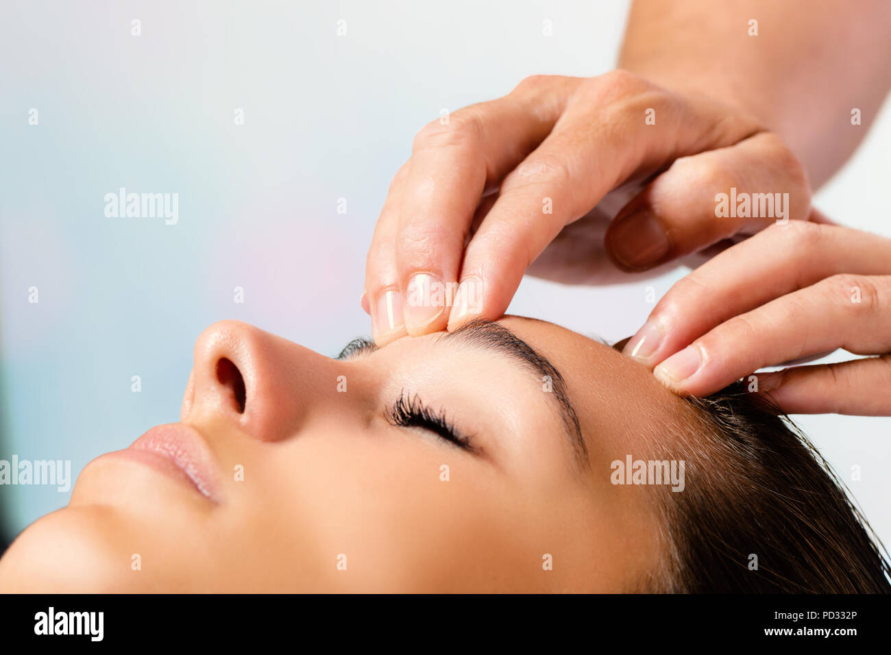 Close up portrait of woman bénéficiant d'un soin de beauté. Thérapeute de massage mains front. Banque D'Images