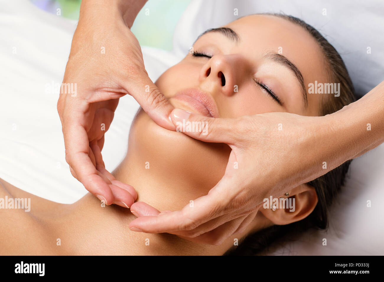 Portrait de femme beauté du visage traitement en spa. L'application de produit cosmétique revitalisant thérapeute sur menton. Banque D'Images