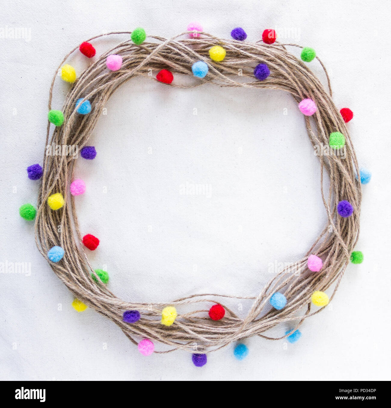 La ficelle de jute, jute, couronne, avec chaîne, des pompons multicolores sur fond écru tissu coton brut Banque D'Images