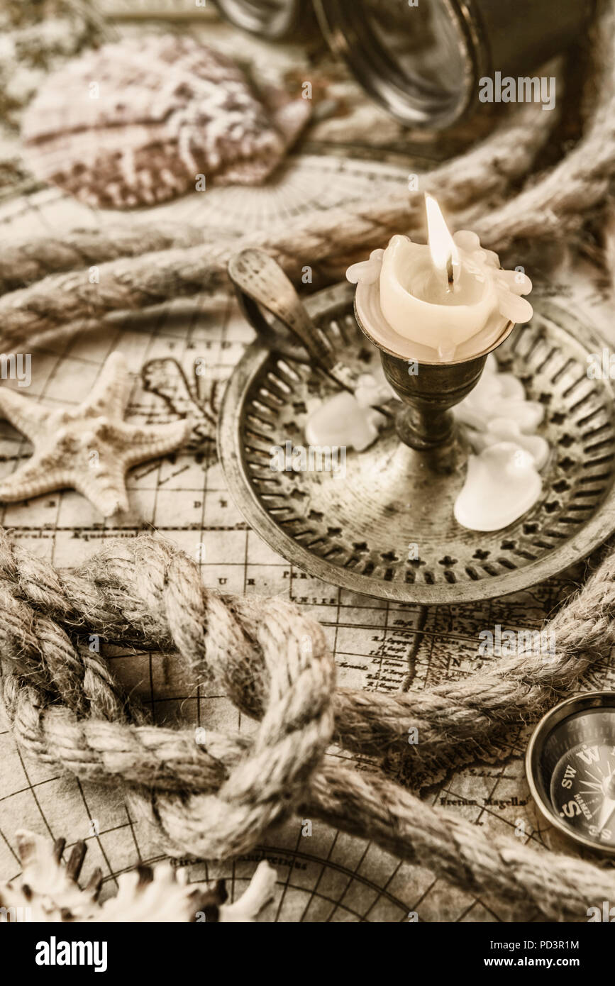 Bougie allumée, boussole, étoiles de mer, des jumelles et la corde du navire situé sur le fond de carte ancienne Banque D'Images