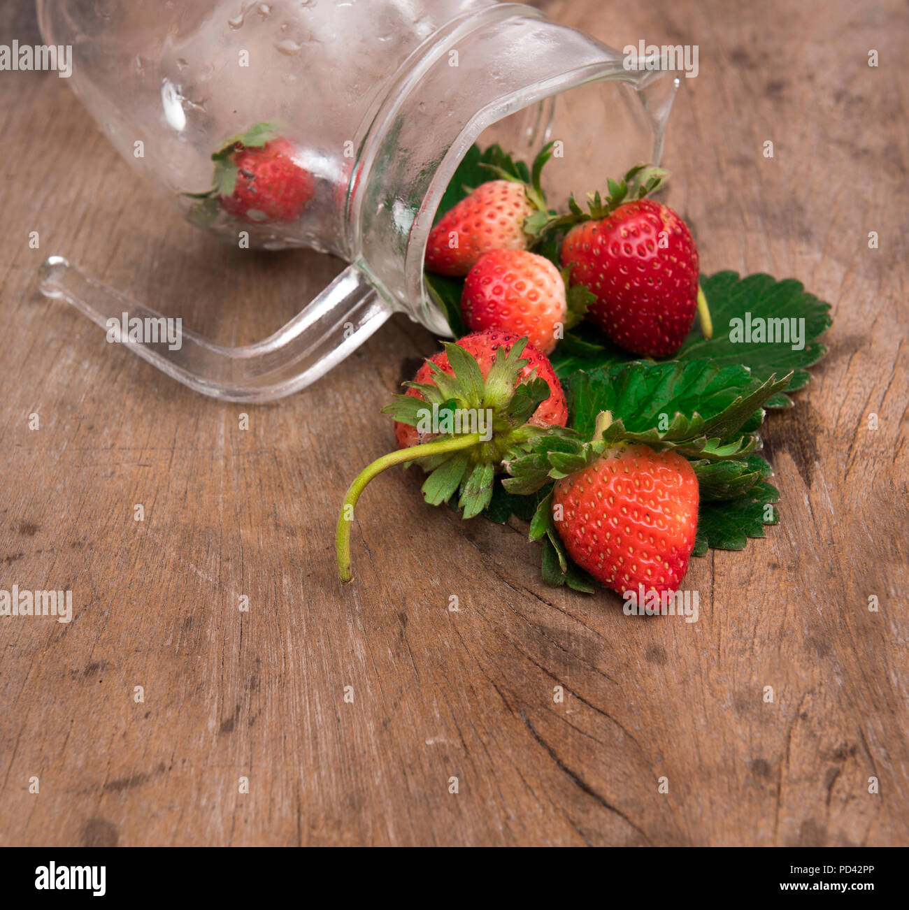 Fraise rouge dans le flacon en verre sur fond de bois Banque D'Images