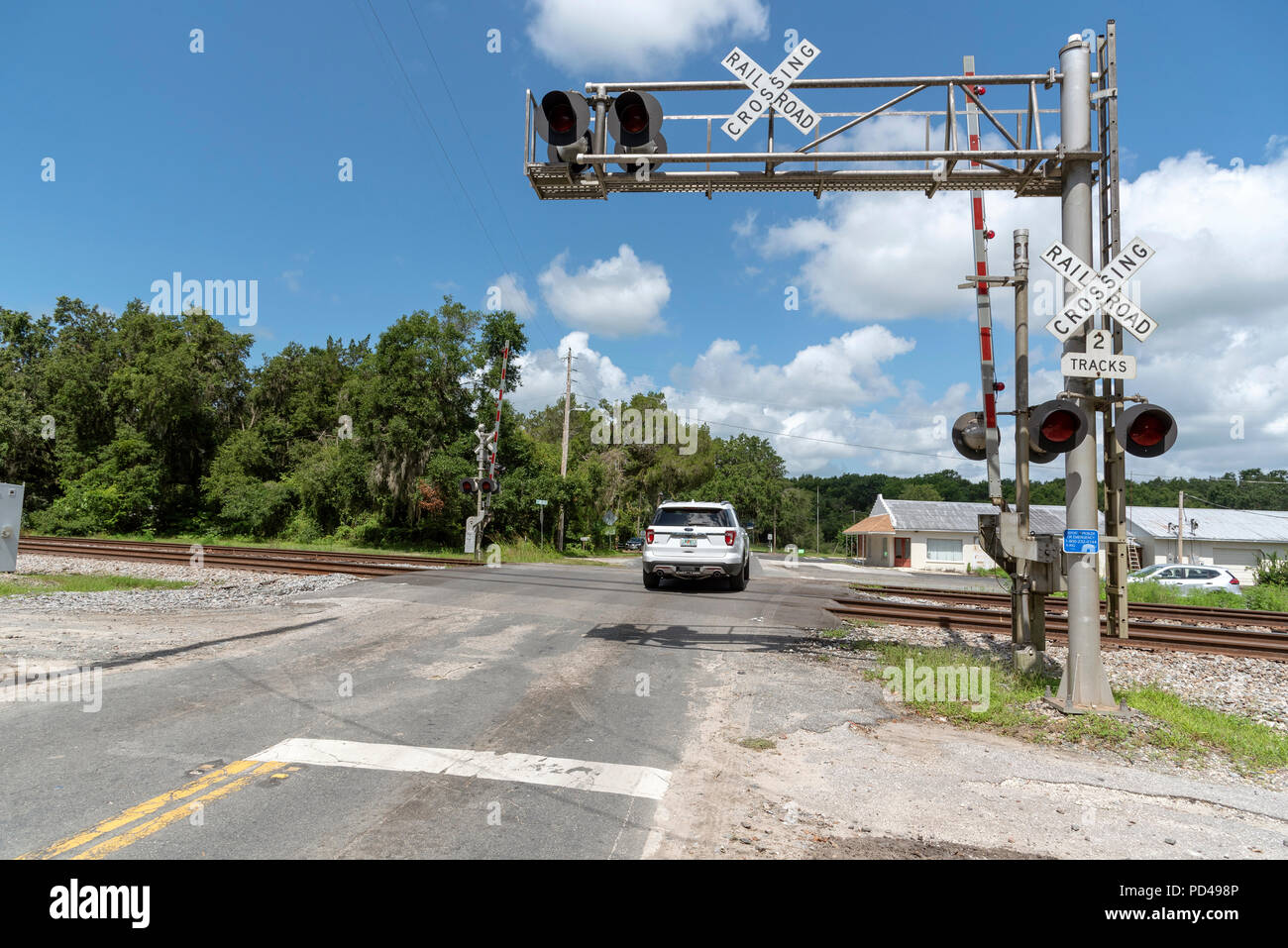 Summerfield, Florida, USA, 2018. Signaux du chemin de fer et la voie passant par campagne en Floride du Nord. Voiture en traversant la jonction. Banque D'Images