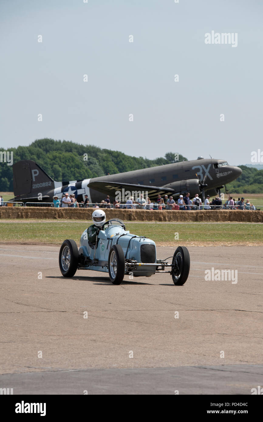 Voiture de course Vintage Frazer Nash en face d'un avion Dakota Douglas au volant de Bicester Bicester Festival, Centre du patrimoine mondial, Oxfordshire, Angleterre Banque D'Images