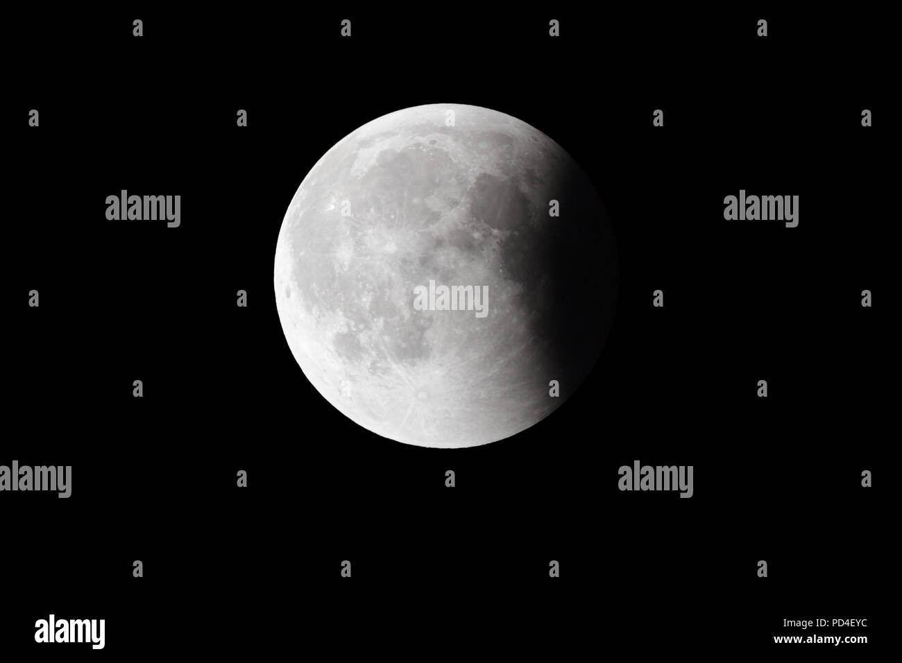 Lune sanglante Super, dernière phase eclipse complet contre le fond de ciel noir, quart de la lune la surface recouverte par l'ombre de la Terre Banque D'Images