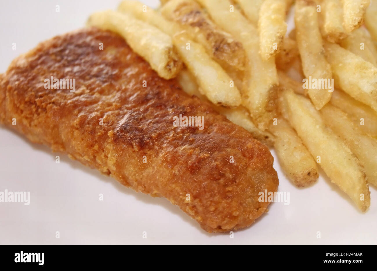 Partie du poisson cuit au four avec un côté de pommes frites Banque D'Images