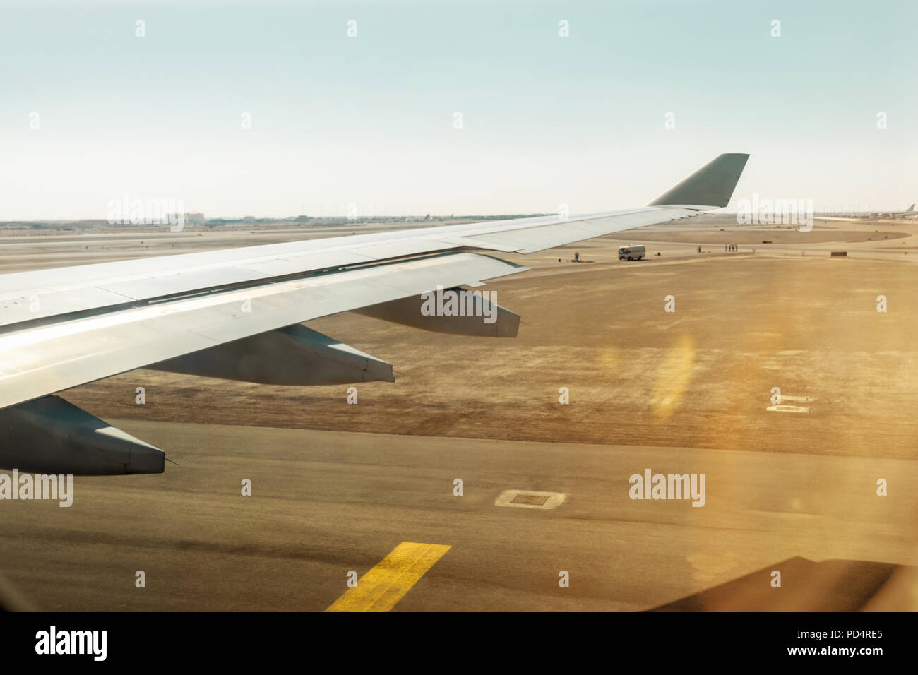 Vue aérienne de la fenêtre de l'avion tout en décollant de la piste de l'aéroport avec désert et ciel bleu Banque D'Images
