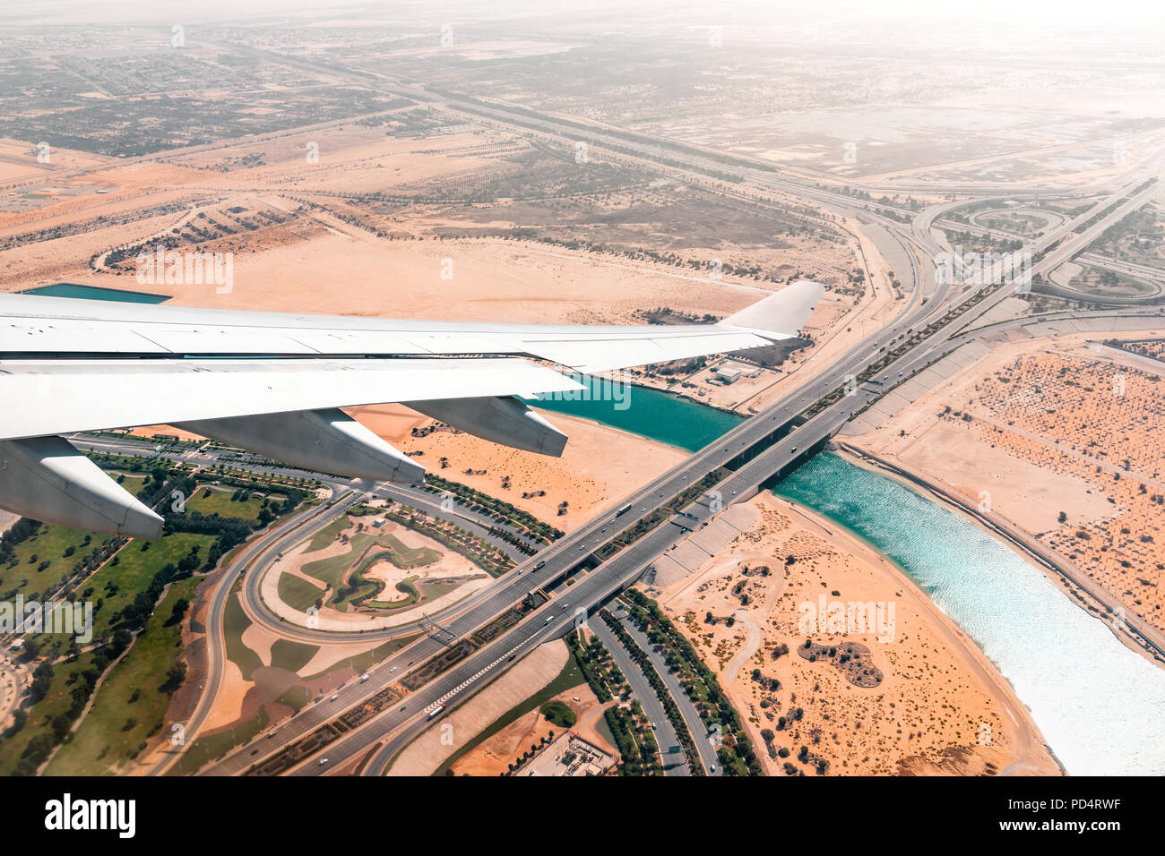 Vue de la fenêtre de l'avion dans le désert au coucher du soleil orange Banque D'Images