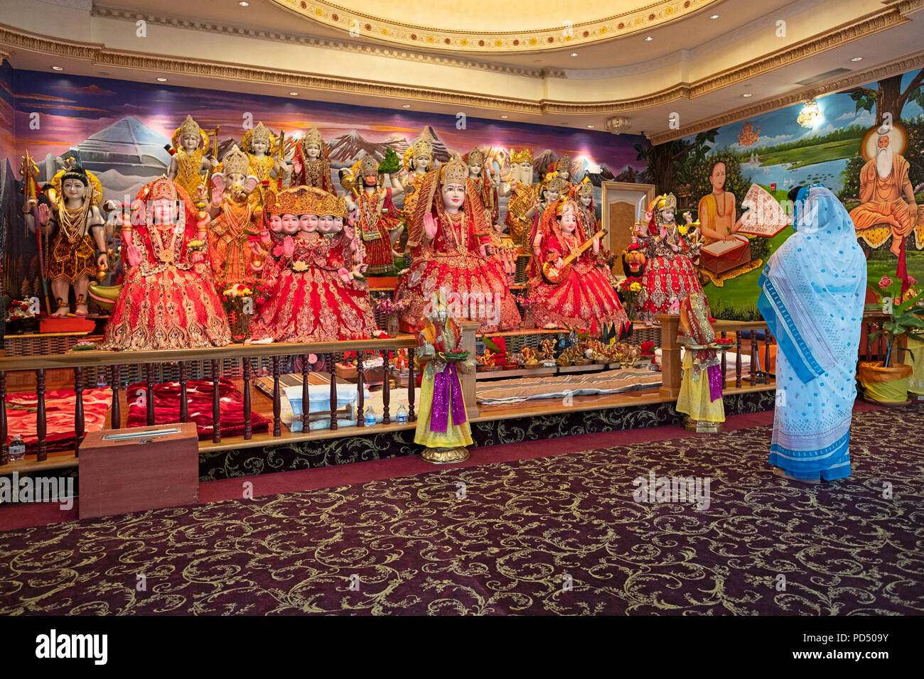 Une femme seule, priant et méditant devant un autel avec des statues de divinités hindoues. Au Mandir Tulsi dans South Richmond Hill Queens. Banque D'Images