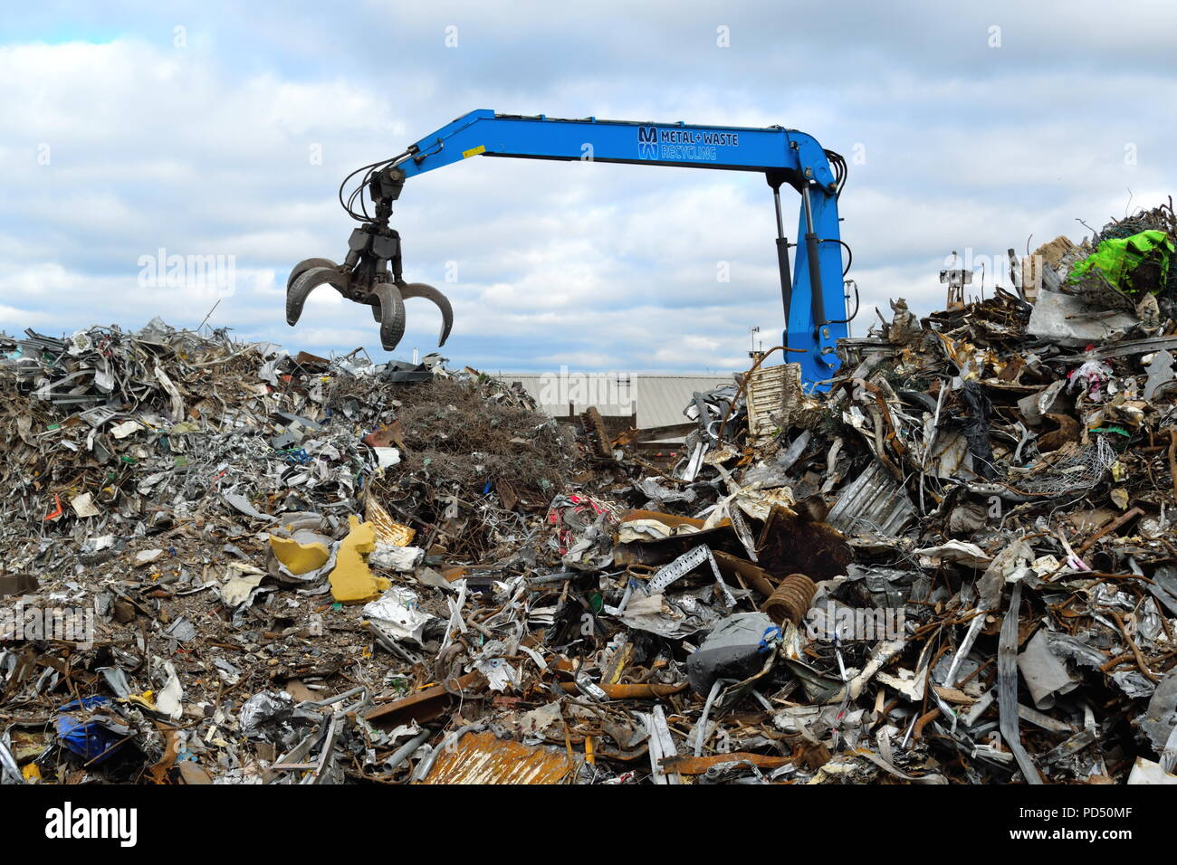Machine d'excavation avec de grandes griffes de pince sur le site de recyclage de ferraille à Edmonton Industrial Estate, Londres. Banque D'Images
