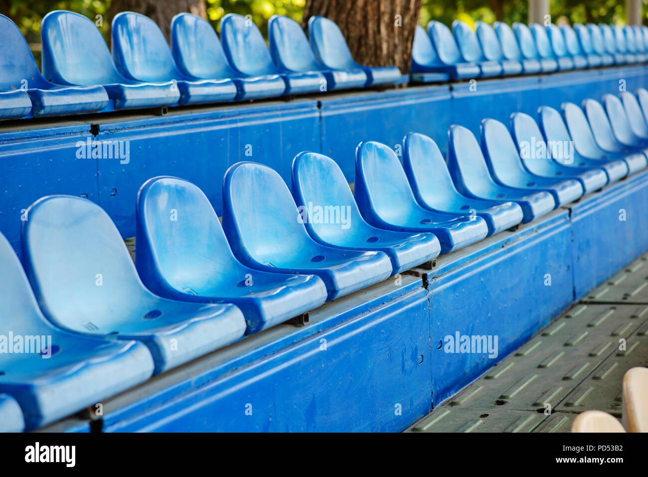 Des chaises en plastique vides dans les gradins du stade. Banque D'Images