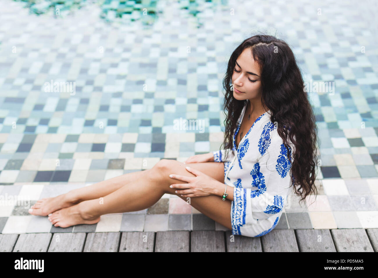 Belle fille de tunique blanche bénéficiant au bord de la piscine de luxe  Photo Stock - Alamy
