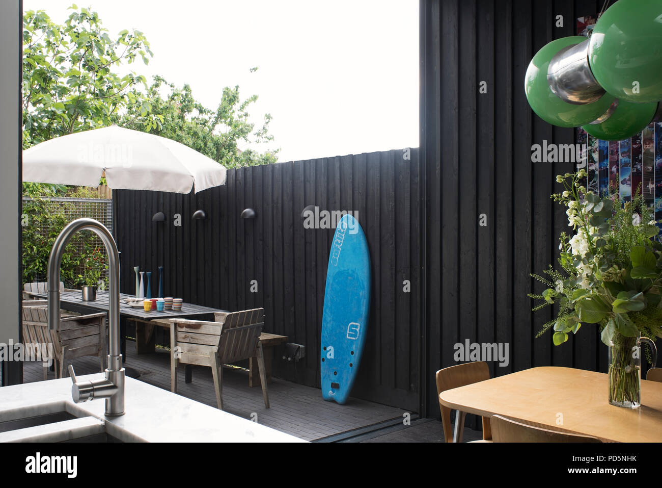 Vêtu de bois de style extérieur terrasse avec meubles de jardin et de planches de surf Banque D'Images