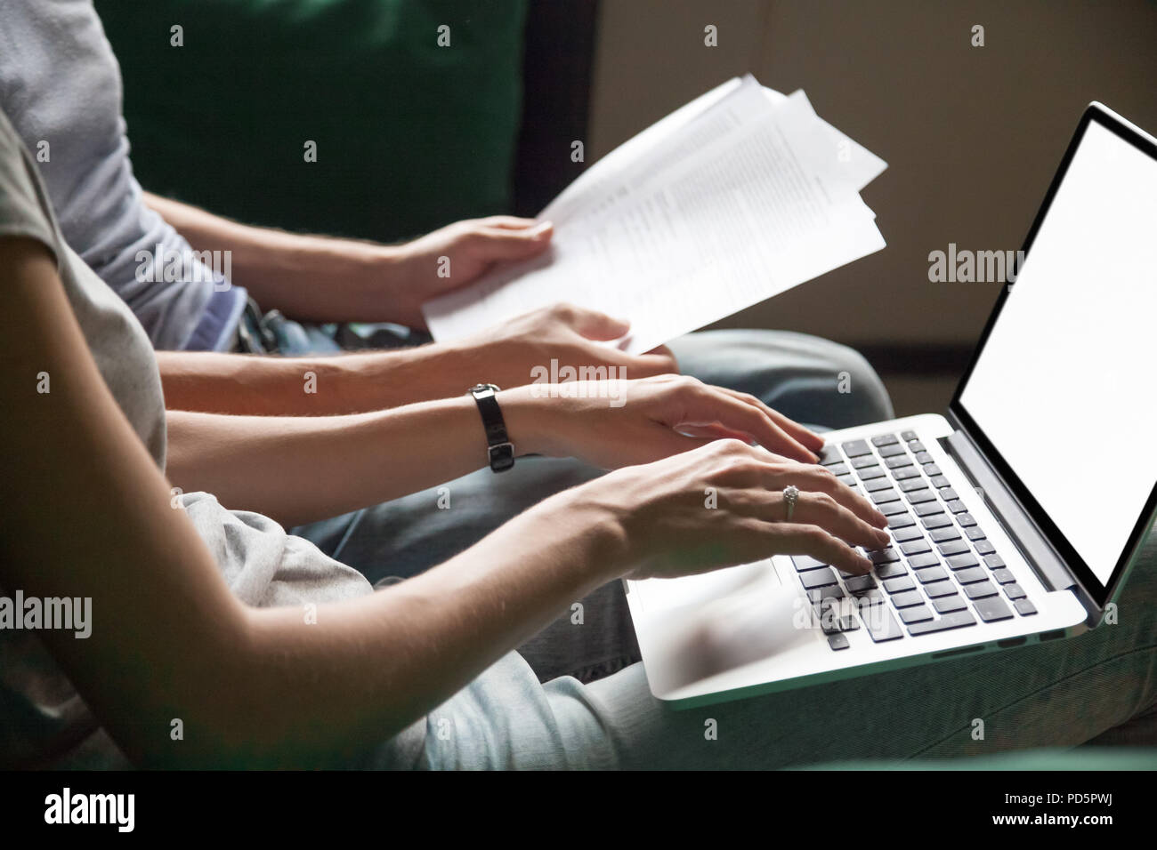 Couple holding la lecture de documents à la maison avec un ordinateur portable, Close up Banque D'Images