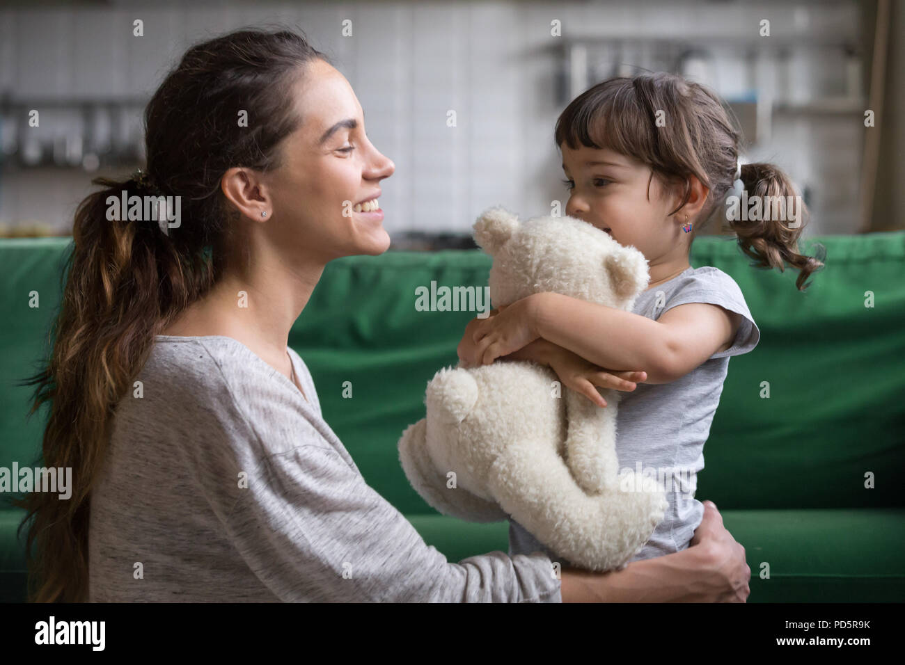 Smiling mother hugging mignon fille montrant l'amour et de soins Banque D'Images