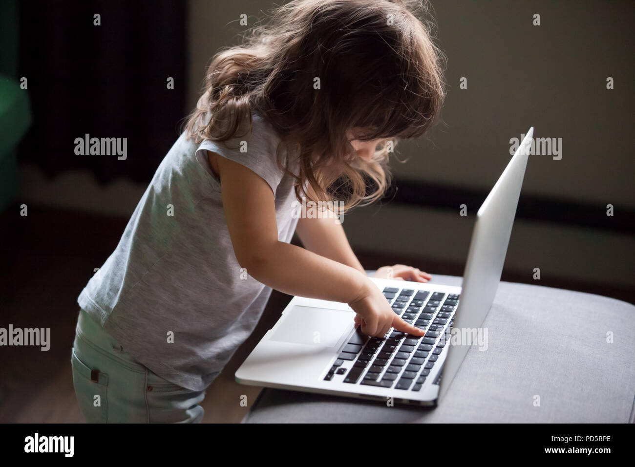 Curieux girl using laptop, pc de contrôler la sécurité d'enfant concept Banque D'Images