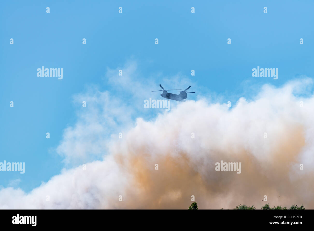 HENGELO, Pays-Bas - 1 juillet 2018 : l'armée néerlandaise de l'hélicoptère Chinook éteint un grand incendie dans une entreprise de traitement des déchets à l'échelle locale pendant un été chaud Banque D'Images