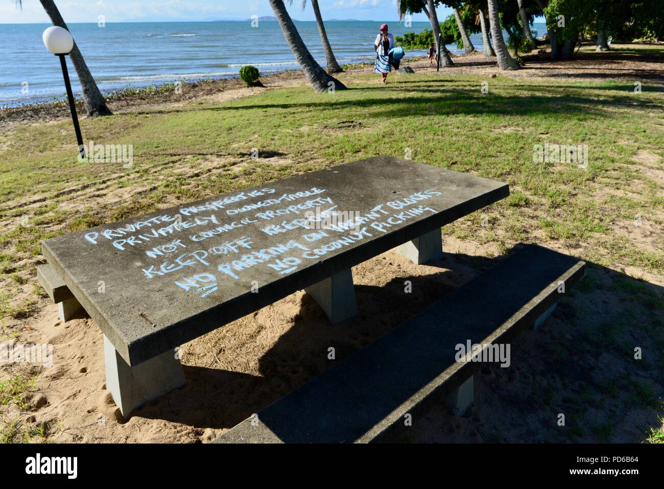 Table en béton sur un terrain public avec un message d'avertissement de ne pas utiliser, Toolakea QLD, Australie Banque D'Images