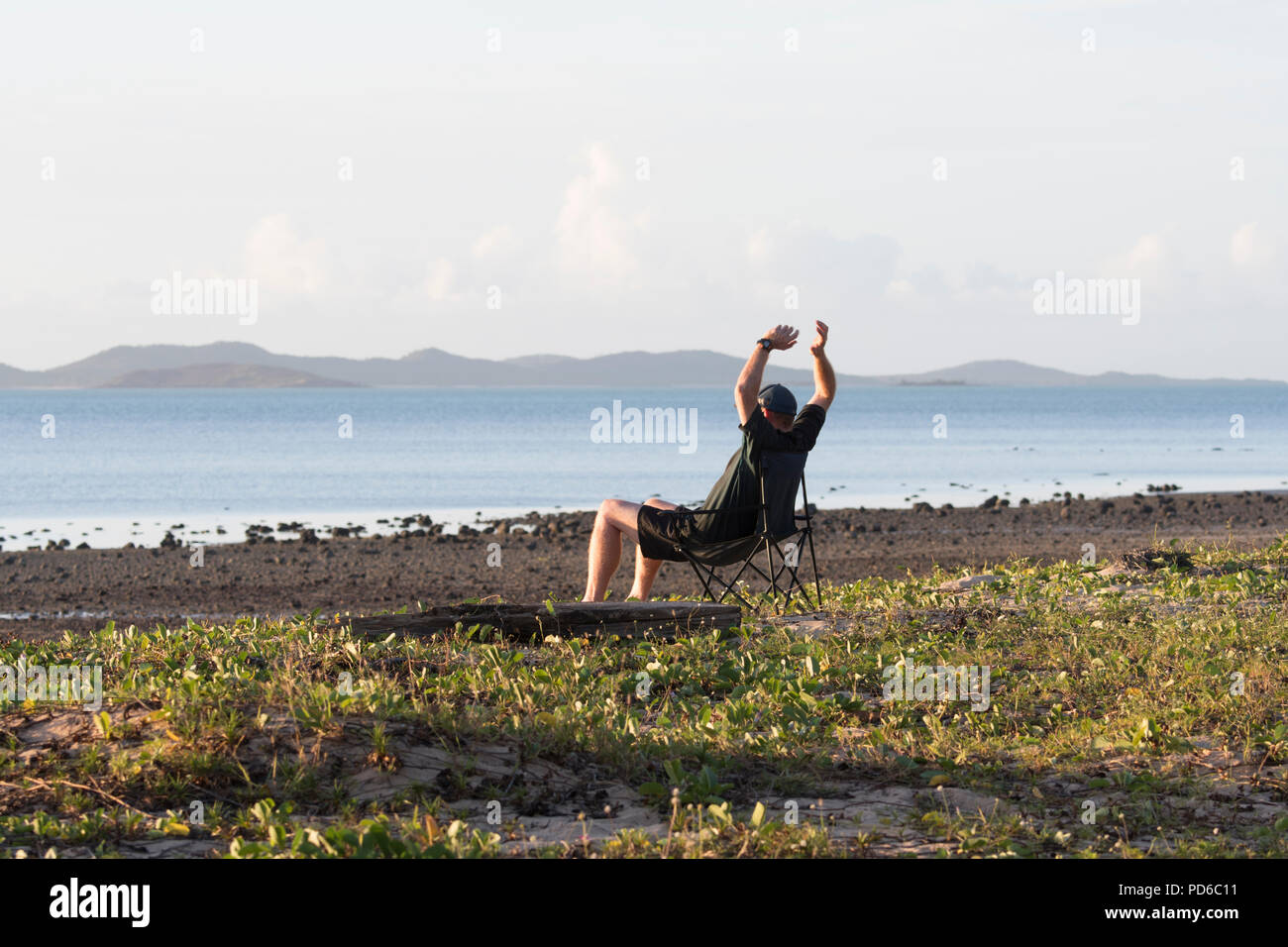 L'homme de vous détendre sur une chaise à Seisia, plage de fidélité, la péninsule du Cap York, Far North Queensland, Queensland, Australie, FNQ Banque D'Images