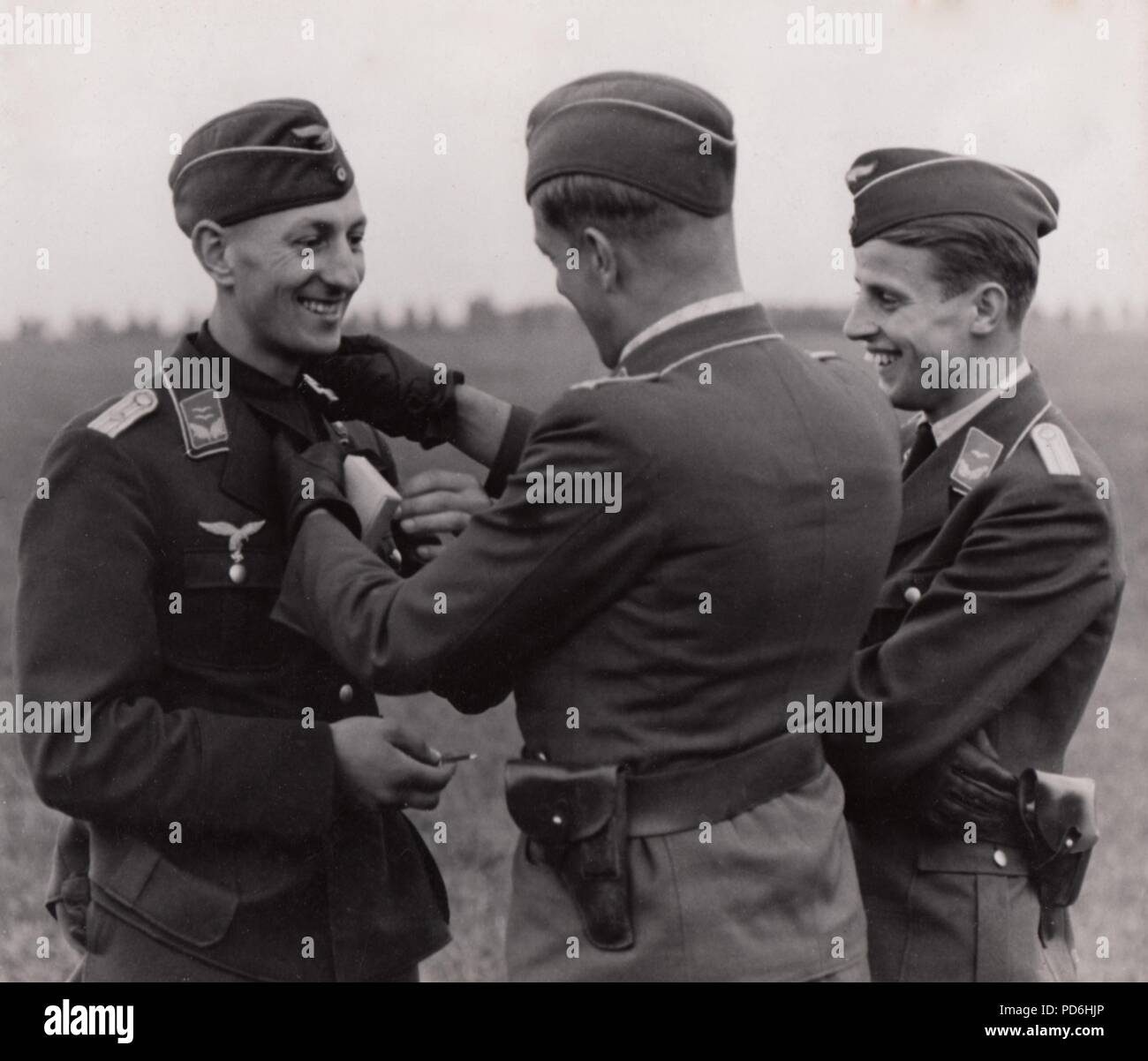 Droit de l'album photo de l'Oberleutnant Oscar Müller de la Kampfgeschwader 1 : Dans un moment ludique, l'Oberleutnant Zeitler du 5./KG 1 reçoit la Croix de Fer de 1re classe à l'Aérodrome de Rosiére, France, en septembre 1940. L'épinglage est l'agent de présentation de la bourse à la gorge, dans Henri Blocher la position de la Croix de Chevalier de la Croix de fer. Le lieutenant Oscar Müller est sur la droite du trio. Banque D'Images