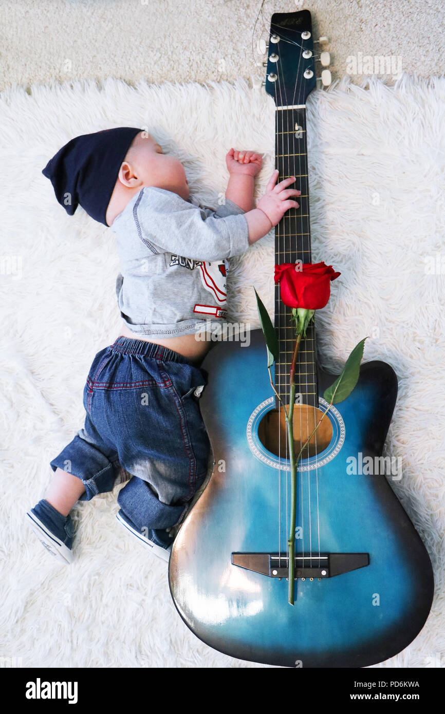 Mignon Petit Bebe Portant Des Vetements Style Rock Dormir Sur Une Couverture Laineux Blanc Hugging Guitare Avec Rose Rouge Couche Sur Elle Love Serenade Concept Photo Stock Alamy