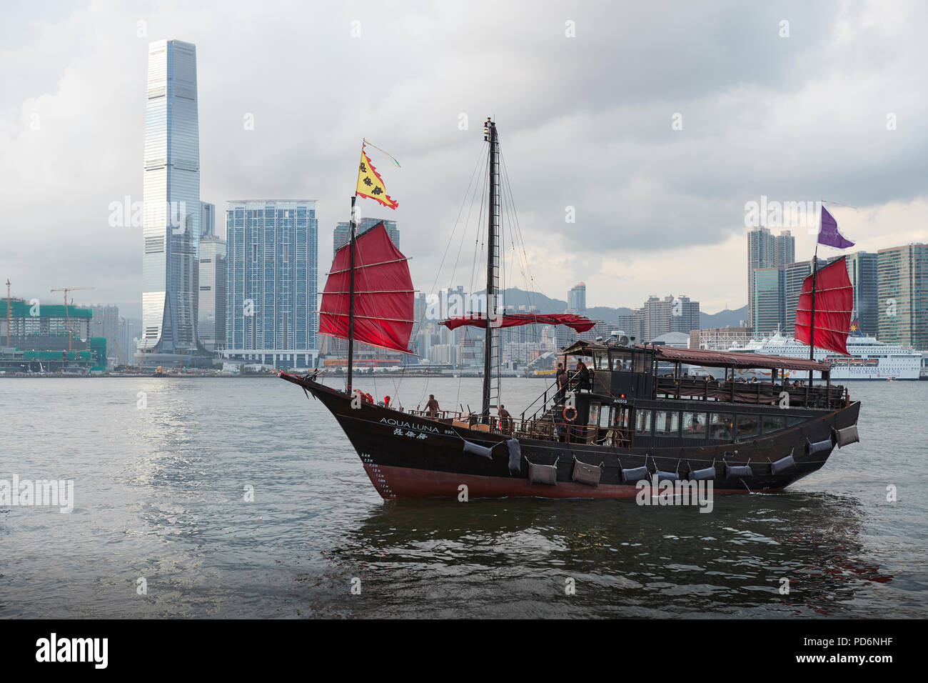 Aqualuna Croisière sur le port Victoria Harbour Passage Jonque Chinoise, Hong Kong. La ville de Kowloon à l'arrière-plan. Banque D'Images