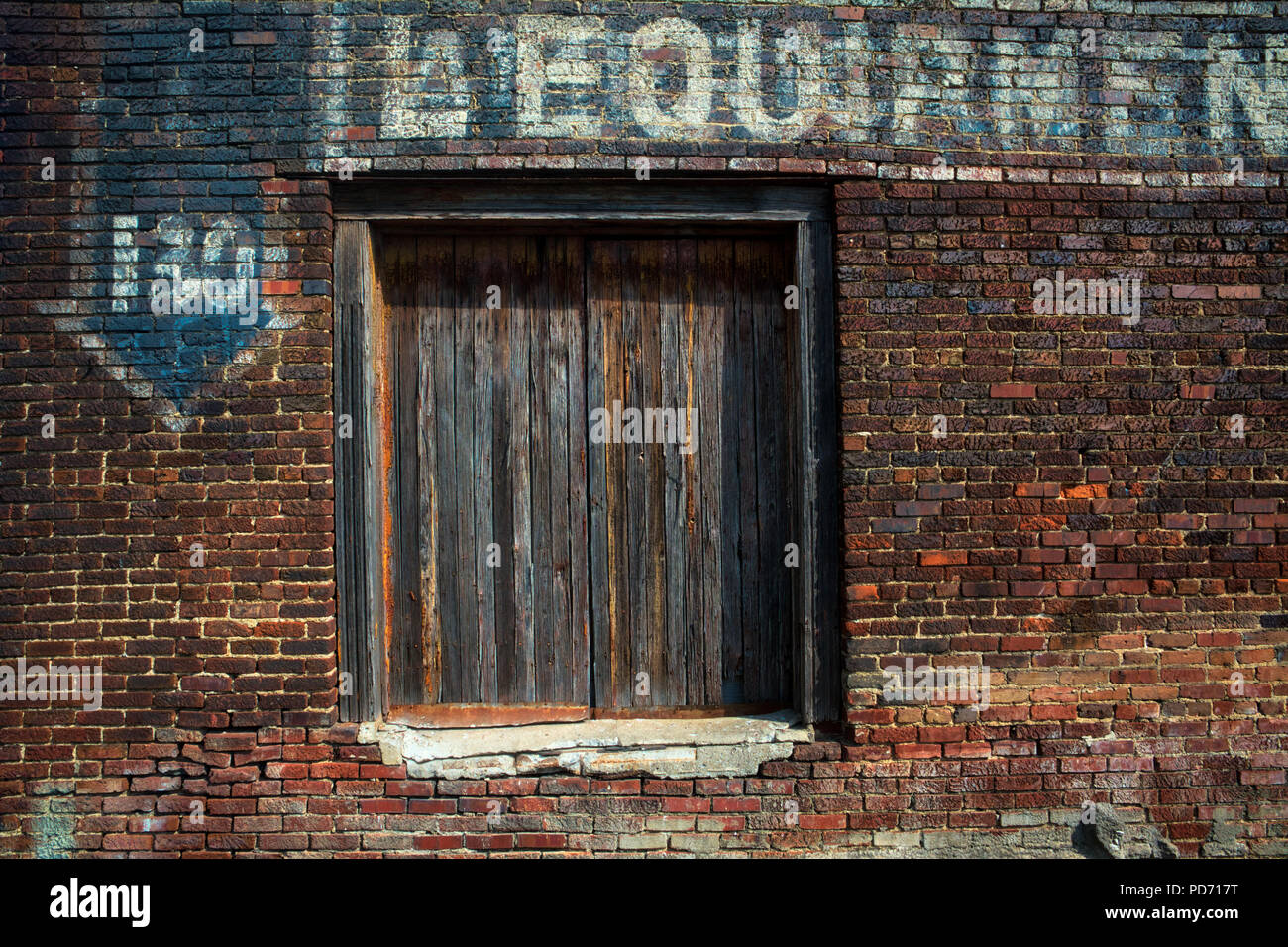 Une porte en bois patiné et vieux, fading publicité peinte sur le côté d'un mur de brique rouge à Nashville, Tennessee Banque D'Images