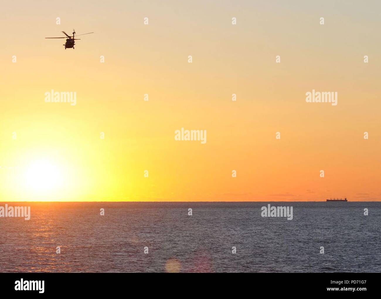 Un hélicoptère MH-60R Seahawk hélicoptère affecté à l'Escadron grève maritime (HSM) 70 et le porte-avions USS George H. W. Bush (CVN 77) vole au-dessus de l'océan Atlantique au lever du soleil le 17 octobre 2010. George H. W. Bush est la conduite du navire sur mesure la disponibilité de formation/Évaluation finale du problème. (U.S. Photo par marine Spécialiste de la communication de masse de la classe 3ème Tony Curtis/libérés) Banque D'Images