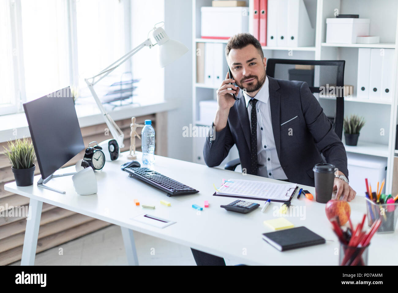 Un homme est assis au bureau au bureau, parler au téléphone et à la droite  Photo Stock - Alamy