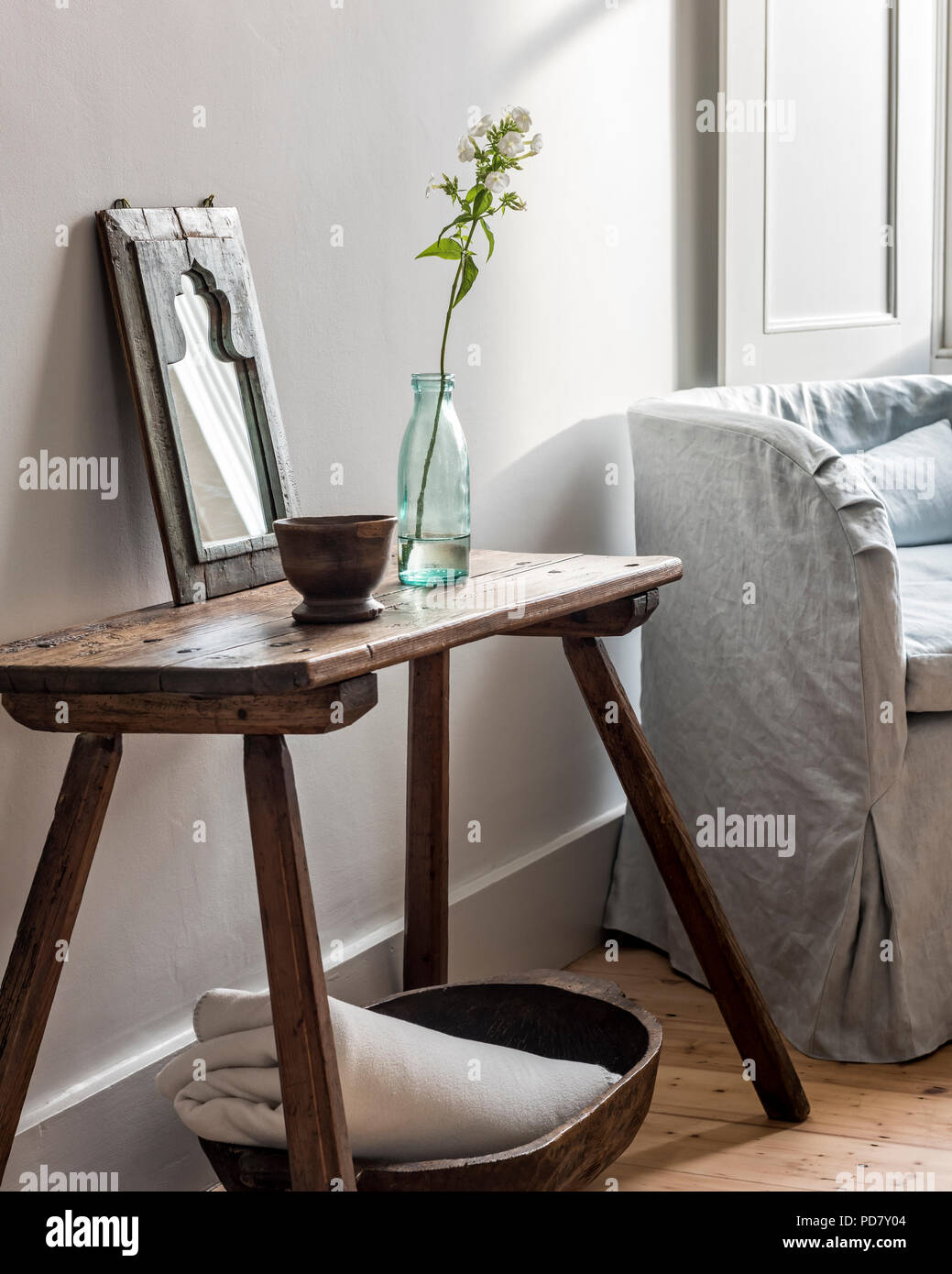 Tabouret rustique dans la chambre à côté du petit fauteuil recouvert de  draps de Rose uniacke Photo Stock - Alamy