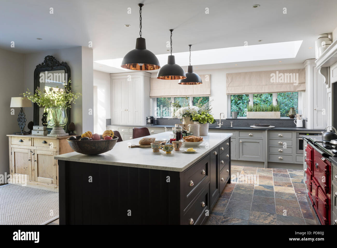 L'île de cuisine sur mesure par Thomas Ford & Sons est peint en brun Tanner par Farrow & Ball. Pendentif style industriel suspendu au-dessus de feux Banque D'Images