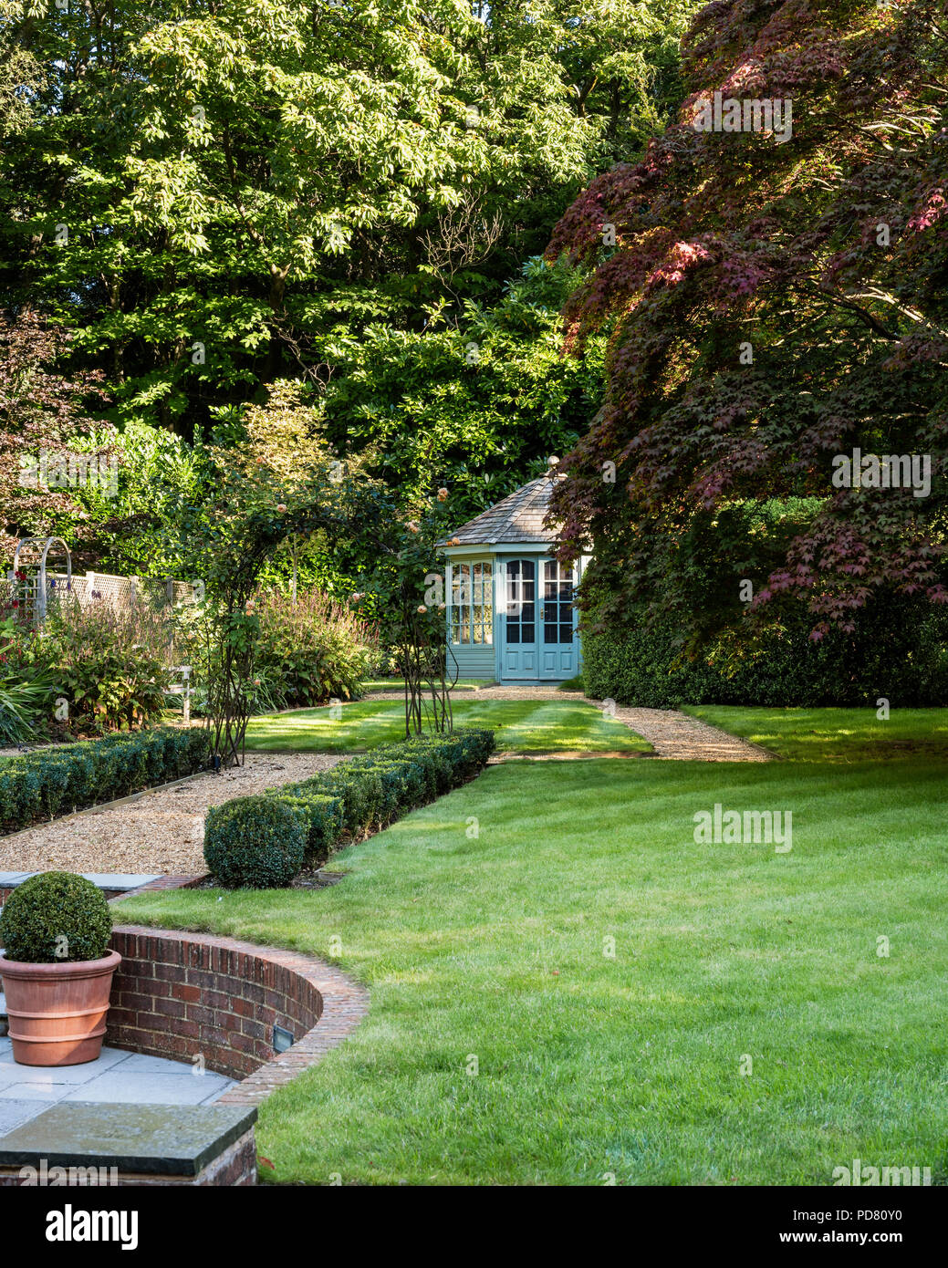 Neat country garden avec fort haie et maison d'été Banque D'Images