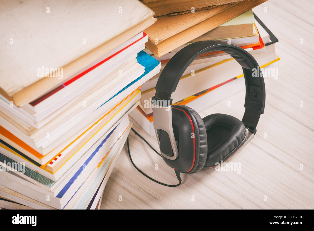 Les écouteurs et les livres en papier. Concept d'écouter des livres audio. Banque D'Images